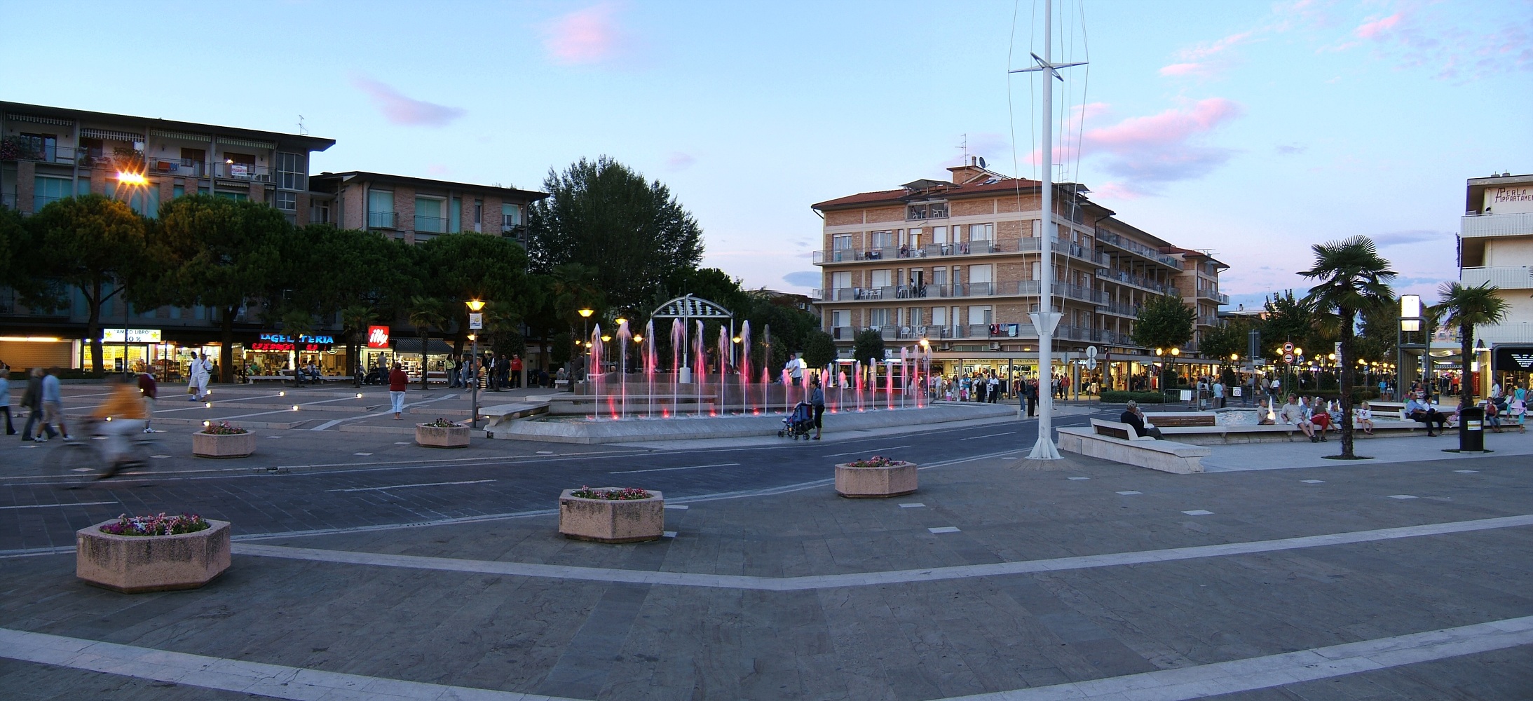 La piazza e le fontane nel centro di Bibione al tramonto